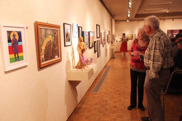 Long-time Mabee-Gerrer Museum of Art supporters, Megan Clement and Chris Rick, check out the donated art pieces before they are chosen at the annual "Off the Wall" event on April 24.