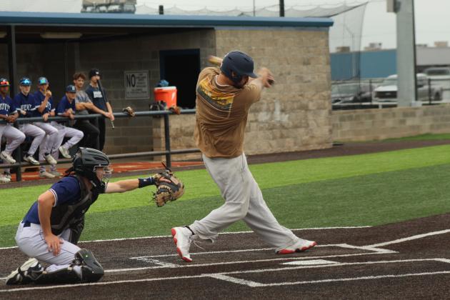 Shawnee Alum Gunner Wright swings his heart out, as SHS catcher, sophomore Cruz Winsett reaches for the catch, during the Alumni Game on April 25.