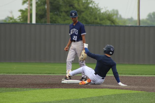 Shawnee Alum Eli Davis slides to steal second, as freshman Micco Carolina looks on, during the Alumni Game on April 25.
