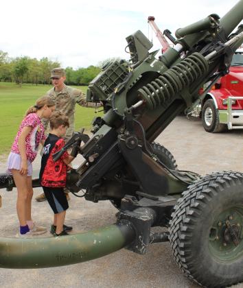 U.S. Army E4 Josh Wilson supervises as Peyton Poulton, 11, and James Poulton, 8, both of Morrison, OK, raise and lower an M119A3 canon during Touch-A-Truck and Beyond, held at the CPN Festival Grounds on April 11 and organized by Pottawatomie County Emergency Management.