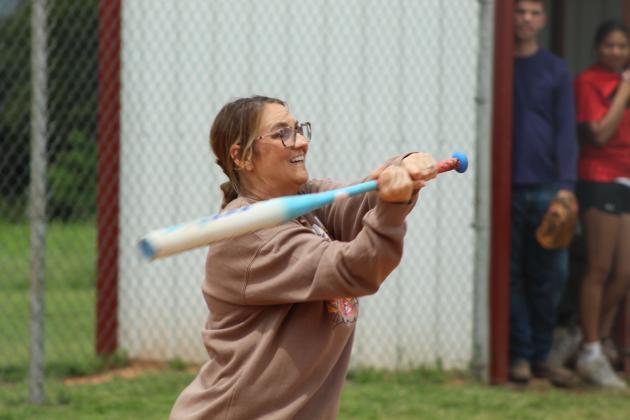 Macomb Counselor Donnell Riggs keeps her eyes on the ball during the Macomb Staff vs. Players Game on April 29. In its first year, about 12 staff members (and a couple parents) from Macomb Public Schools played members of the baseball and slow pitch teams.