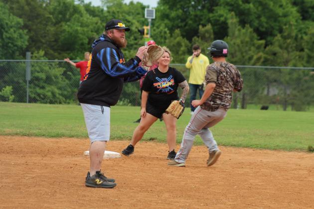 Pitcher Dustin Daily waits for the catch, as Stephanie Daily tries to block baseball player Christian Flowers from second base during the Macomb Staff vs. Players Game on April 29. The Daily's are the parents of freshman slow pitch player Paitynn Daily and "helped coach first base" at a couple games, said Coach James Hancock.