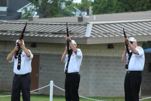 The Shawnee VFW Post 1317 Honor Guard fires a 21-gun salute during the Shawnee Memorial Day ceremony at the Woodland Veterans Park on May 25. They are, from left, Don Plumley, Michael Schafer and Chris Hickman.