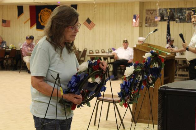 Tecumseh American Legion Auxiliary member Charlene Johnson places a wreath for the POWs, MIAs and KIAs during the Memorial Day ceremony on May 25 at Post 260.