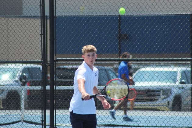 Shawnee's Connor Taylor hits with a backhand stroke during the Shawnee NGB Tournament, held at SHS and OBU on May 2. Taylor was on the Extra Doubles team with Grady Smith.