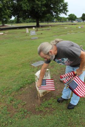 Shawnee VFW Post 1317 Adjutant and Sr. Vice Commander Don Plumley places a flag on the grave of Pvt. Albert Armstrong, who was in the General Hospital Medical Department, at Fairview Cemetery in Shawnee on May 23. Plumley was among several people who decorated the veterans' graves that morning.