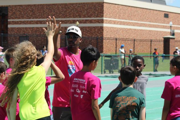 Charles Clark, gives high fives all around after a race at the Health Week Track Clinic, held at Oklahoma Baptist University on May 28.