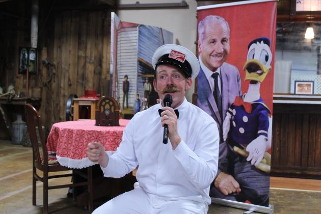 Nick Waters with American Storytellers, LLC, tells the story of Clarence "Ducky" Nash, the voice of Donald Duck for 50 years, on June 8 at the McLoud Museum and Historical Society. Presented by the McLoud Public Library, Waters told how Nash was born in Watonga, OK, where he imitated the animals on their farm as a child, including a baby goat which he voiced. His family moved to Mt. Washington, MO, when he was 10, and at 15, he performed in a talent show. Nash became a milkman before working for Disney.