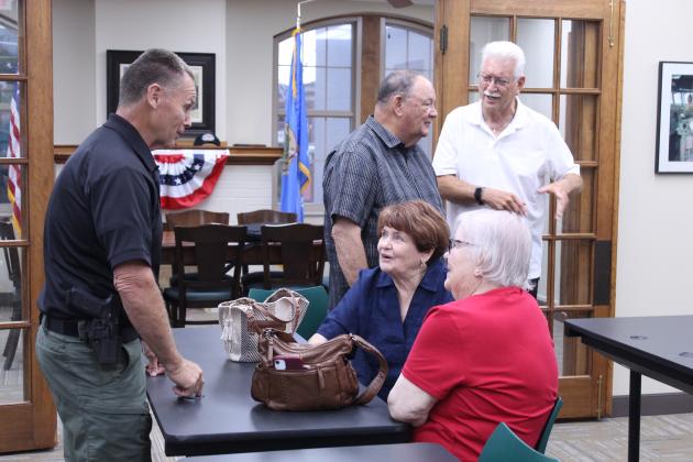 Sheriff Freeland Wood speaks with Linda Robinson and her sister Ann McDonald, as retired Brig. Gen. Ben Robinson talks to veteran Jerry Shiles.