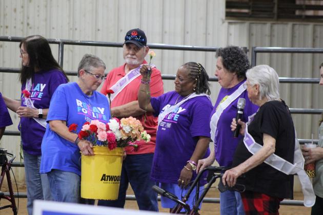 Relay for Life of Pottawatomie County Co-Chair Jana Grubbs hands out carnations to cancer survivors after they tell about their journey during the event, held at the Heart of Oklahoma Expo Center Fred Humphries Arena on May 29. Cancer survivor Nikki Robinson was the speaker that night. There were 54 registered survivors at RFL this year, and 11 area teams raised $28,299 for the American Cancer Society, as of June 1. Photos by Natasha Dunagan, Countywide & Sun