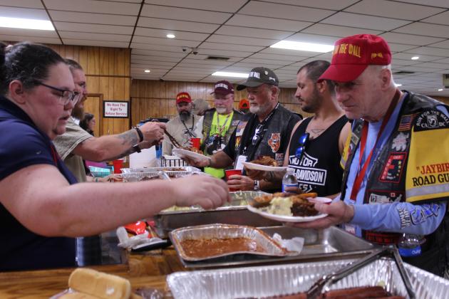 Incoming VFW Post 1317 Commander Brandy Schafer, left, serves beans to veterans on the Run for the Wall on May 16.