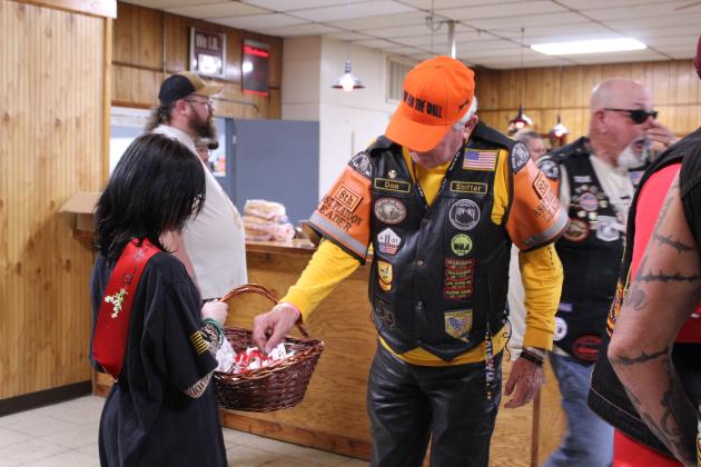 Army veteran Don "Shifter" Hughes of Las Vegas, NV, selects a "Buddy" poppy offered by Emmy Keathley, 14, of Shawnee, during the Run for the Wall food stop at the Shawnee VFW on May 16.