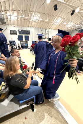 J’Kub Medrano gives a rose to their mother during the Asher graduation ceremony.