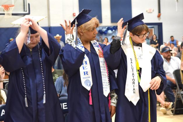 Bethany Idell, J'Kub Medrano and Landon Dodge turn their tassles, signifying their high school graduation.