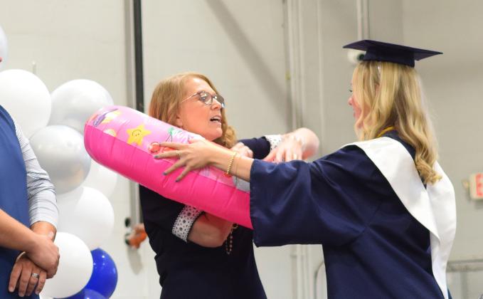 Presley Danae Taylor adds another swim tube to Mrs. Magby on her stroll across the stage for her diploma.