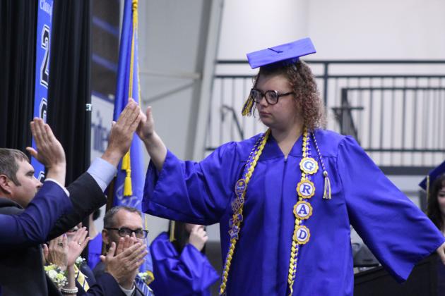 Emma Lily Steward gets high fives from the Bethel School Board before receiving her diploma at the Bethel High School Graduation, held on May 16 in the BHS gym.