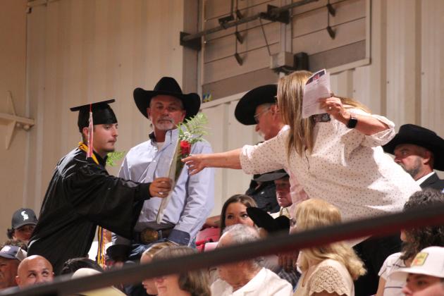 Earlsboro High School graduate Brayden Rawls hands a rose to his grandmother Connie Rawls during commencement on May 8 at the EHS Gym.