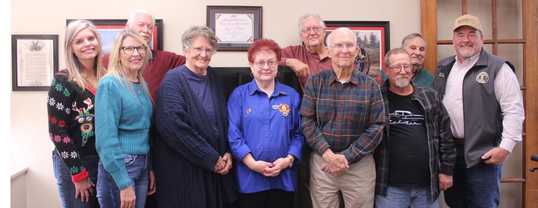 Members of the Shawnee Veterans Memorial Committee pose with local artist Joyce Marsh and the Pott. Co. Commissioners at the Pott. Co. Veterans Educational Museum in Dec. 2025. Prints of Marsh's military artwork, which belonged to Bill Ford, decorate the museum. Shown, front row from left, are County Commissioners Abby Thompson and Melissa Dennis, Marsh, Barbara White, Ford, James Bryce, County Commissioner Greg Rush, back row, Jerry Shiles, Museum Director Doug Warden and Douglas Dollar. File photo