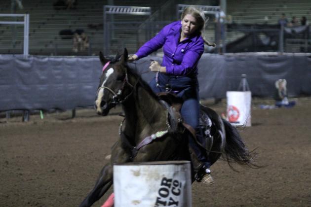 Josey Milburn of Asher is careful to steer around the third barrel in the barrel racing event of the International Finals Youth Rodeo on the evening of July 13.