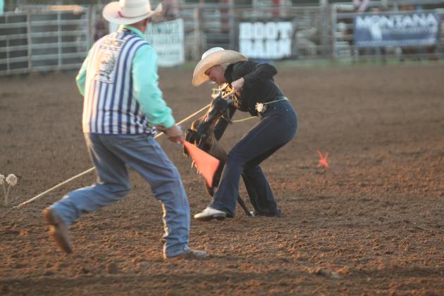 Rianne Tinsley of Shawnee works on tying her goat in the International Finals Youth Rodeo on the evening of July 13.