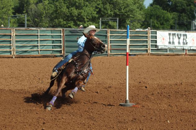 Danni Brown of Bethel rounds an end pole in the pole bending event of the International Finals Youth Rodeo on the morning of July 14.