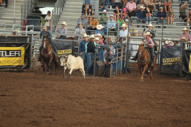 Kolton Yeager of Shawnee, right, aims for the horns while team roping with Austen Schreckhise of Weatherford, TX, during the IFYR on the evening of July 16.