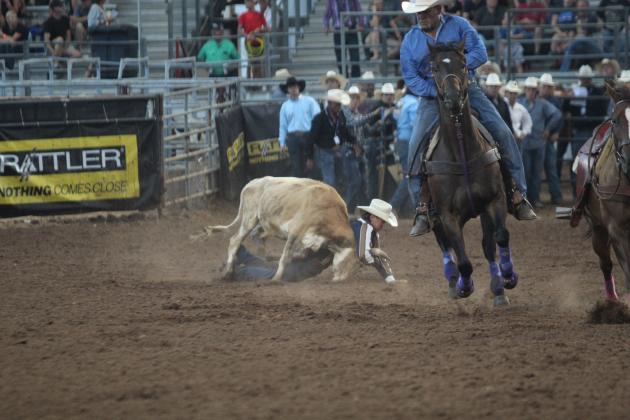 Bo Spears of Macomb ends up underneath a steer while wrestling its head to the ground during the IFYR championship round on the evening of July 17. He came out on top in 12.2 seconds and placed 10th in the overall event standings.