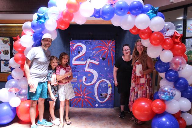 Justin Wood, Harrison Wood, 8, Finley Wood, 10, Dara Massey and Olivia Wood pose in front of the community tile artwork and under a balloon arch, which was created by Shawnee Public Library Customer Experience Manager Becky Roberts and her two nieces, during the "Pop In to Celebrate America's 250th Birthday with Popcorn and Ice Cream" event on June 29. Branch Manager Mary Sims handed out popcorn and ice cream sandwiches, and the celebration would continue with snow cones and birthday cake on the next days.