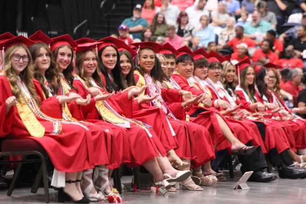 McLoud High School 2026 graduates play the "Gotcha" game, as directed by Senior Class President Mayrin Cerda during graduation on May 23 at FireLake Arena. Cerda told them to look to their neighbor and say, "I'm gonna get you," then try to pull their finger away before their neighbor could grab it.