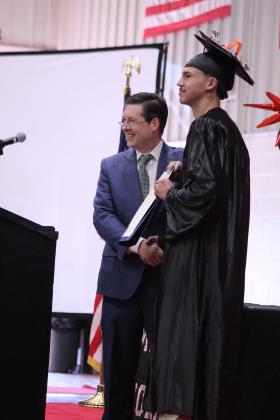 State Senator Shane Jett gives a Senate certificate of citation to Macomb graduate Blayze Lewis during the Commencement Ceremony on May 9. Jett said, "Blayze testified for the Oklahoma legislature, displaying uncommon maturity and strength as he spoke truthfully and respectfully despite heavy pressure, and whereas that direct result of Blayze's courage and willingness to speak out and meaningfully discuss this, meaningful discussions were opened with legislation regarding government overreach."