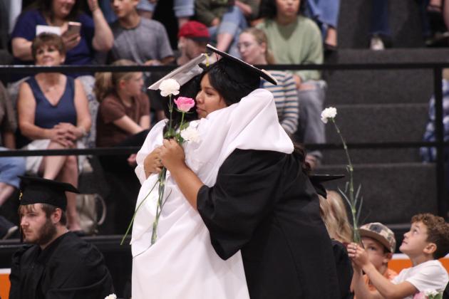 Abigail Horton and Natalie Brown-Harjo share a hug and flowers during Maud High School's Graduation on May 22 at the Ed Harman Gymnasium. Maud graduated 20 seniors.
