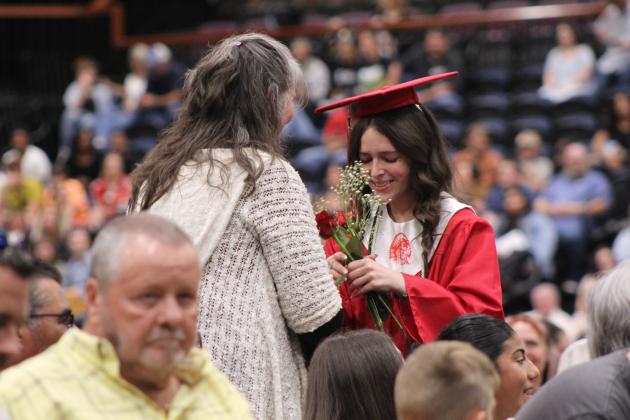 McLoud High School 2026 graduate Kelly Wells presents a flower to someone special during graduation on May 23 at FireLake Arena. There were 92 seniors graduating from McLoud this year.