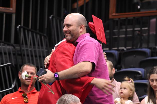 Basketball player and 2026 grad LaDamian Williams gives a flower and gets a hug from Head Boys Basketball Coach Eric Litherland during graduation on May 23 at FireLake Arena.
