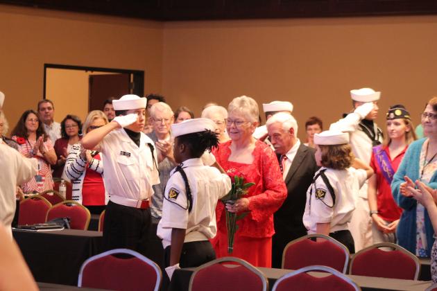 Donna Snodgrass and her husband, Tom Snodgrass, are saluted by the US Naval Sea Cadets and applauded by the audience as they enter the room during the American Legion Auxiilary Department Summer Convention, held at the Grand Casino Hotel and Resort on July 12. D. Snodgrass was sworn in as the American Legion Auxiliary, Department of Oklahoma, President, after serving the past year as the First Vice President. She has been involved in leading  the Sea Cadets for the past 35 years.