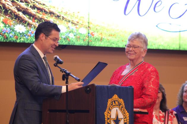 Oklahoma State Senator Shane Jett reads a Senate Certificate of Commemoration in honor of Donna Snodgrass being sworn in as American Legion Auxiliary, Department of Oklahoma, President during the American Legion Auxiliary Department Summer Convention, held at the Grand Casino Hotel and Resort on July 12.
