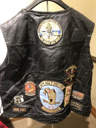 A leather vest belonging to the late Army and Vietnam Veteran Timothy Lawrence is covered with patches.