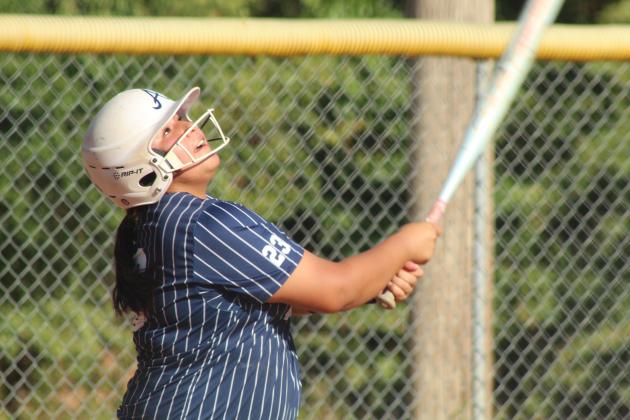 Asher junior Raina Timms smacks a single and watches it fly before running to first in the first inning of the Aug. 20 home game against Carney. The Lady Indians won 12-2, and have a record of 5-1 so far.