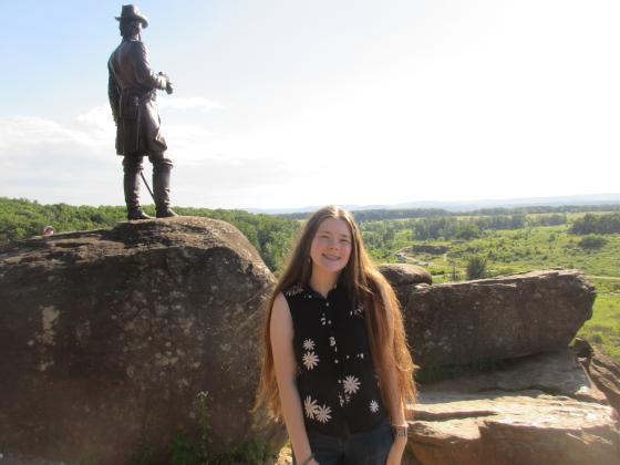 North Rock Creek senior Victoria Nelms stands on Little Round Top by the statue of General Gouveneur Kemble Warren at the Gettysburg National Military Park during the Citizenship Washington Focus leadership program in July.
