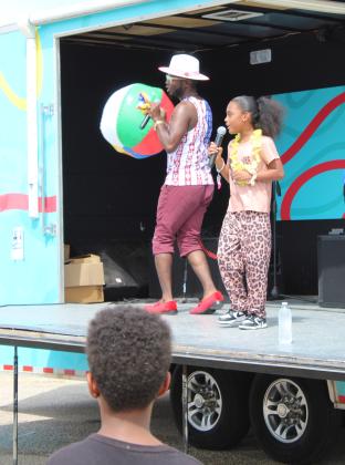 On the Party Peeps stage, Ariana Galban of Shawnee sings "Call Me Maybe," as Jamelle Payne, with CPN Workforce Social Services, prepares to throw a beach ball into the crowd during the Eighth Annual Cops N' Kids, held on Aug. 22 at the Heart of Oklahoma Expo Center. Payne was assisted by Dion Cooley with You're Worthy, LLC, in playing music and entertaining. They also handed out leis and held bike drawings.