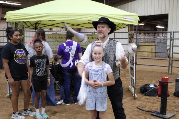 "Jack Spade" (Jeff Hames) of Creative Magic Productions, in Bethel, juggles in front of Addison NeSmith, 9, of Shawnee, during Relay for Life of Pottawatomie County, held at the Heart of Oklahoma Expo Center Fred Humphries Arena on May 29. Spade also created balloon animals, and "Annie Heart" (Valarie Hames) provided face painting at the event.