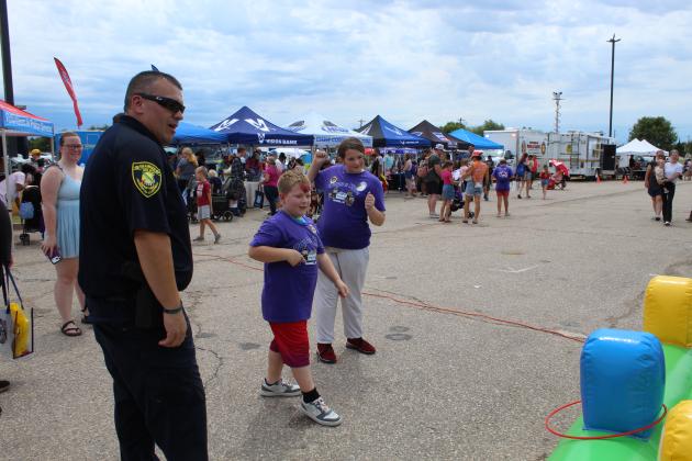 SPD Officer Russell Harjo mans the inflatable ring toss.