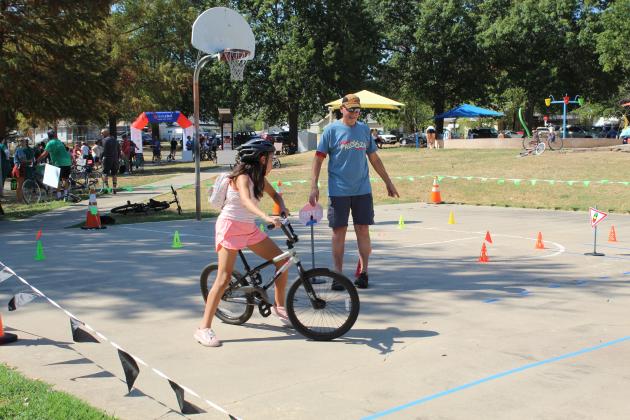 Pottawatomie Go (POGO) volunteer Craig Walker directs M'Chylah Walker, 11, where to go on the bicycle obstacle course during the POGO Pedal Palooza, held at Rotary Briscoe Boy Scout Park on Sept. 19. In addition to the course, the event included 10 vendor and organization booths with face painting, balloon animals, a bike wash and free helmets, a community bike ride, raffles and prizes. Plus, the park's splash pad was available.