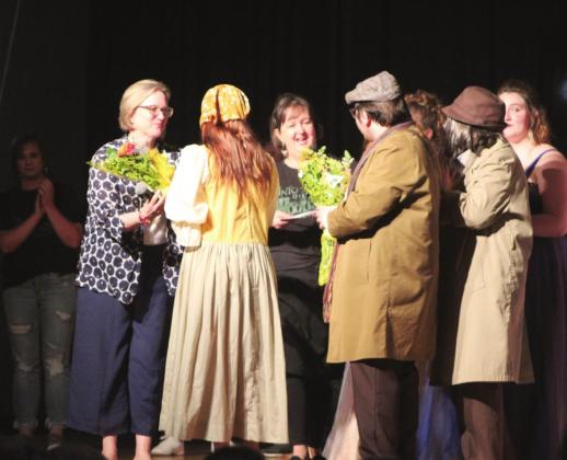 Tecumseh Seniors Lillian Effinger and Jadon Jackson, who played the Baker’s Wife and the Baker, present Tecumseh Vocal Music Director Cheryl Blankenship, far left, and Assistant Director Jill Rother with flowers following the last performance of “Into the Woods Jr.” on April 8 at the THS Alumni Center. Effinger and Jackson also presented a framed collage of portraits taken by former choir student and Tecumseh graduate Baylee Sutton.