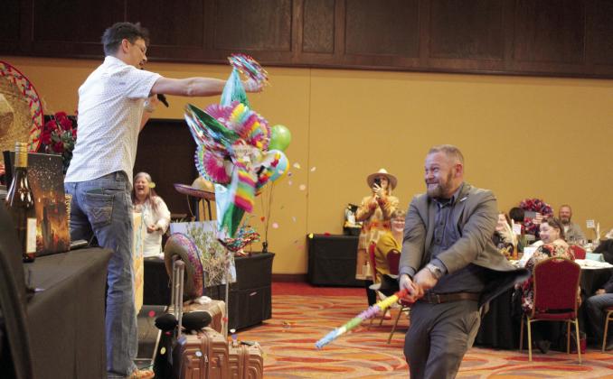 Matthew Danuser swings at the third of three piñatas won during the Tecumseh “Cha-Cha” Chamber Auction, held at the Grand Casino Hotel &amp; Resort on Feb. 8. Countywide &amp;amp; Sun/ Natasha Dunagan