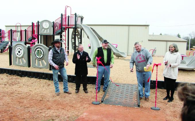 Macomb Superintendent Matt Riggs cuts the ribbon for the new Macomb Elementary School playground on Feb. 6. Applauding are, from left, Chris Johnston of Great Plains Kubota in Shawnee; State Representative Danny Sterling; Pottawatomie County Dist. 2 Commissioner Greg Rush; and Julie McCormick of Gordon Cooper Technology Center. Countywide &amp; Sun/ Natasha Dunagan