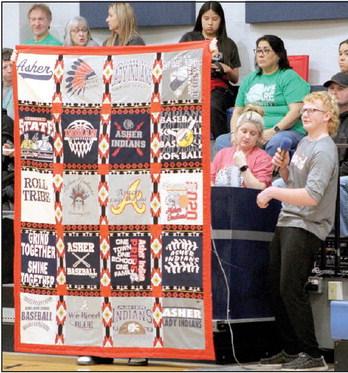 Asher basketball manager Bryson Gregg announces a quilt raffle during halftime of the girls game on Jan. 2. The Asher Indians and Lady Indians T-Shirt quilt was made by Glennie Sanford and will benefit the Asher High School basketball program. The drawing will be held during homecoming. Countywide &amp; Sun/Natasha Dunagan