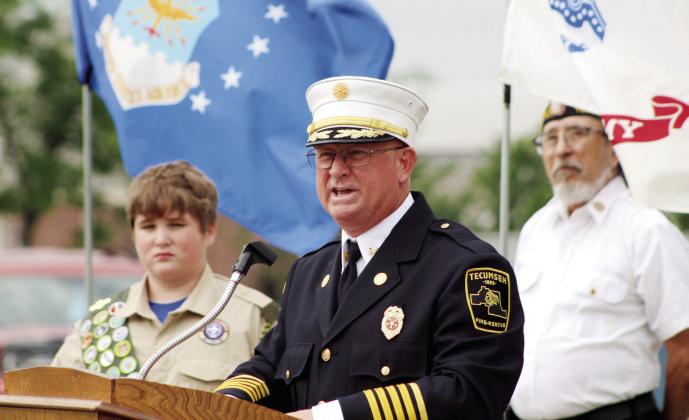 Tecumseh Fire Chief and former U.S. Navy BU3 Rhett Banks speaks about a friend who lost his life in Iraq during the Memorial Day service at Tecumseh Cemetery on May 29. Listening behind him are Scout Robby Byrd, 13, and American Legion Post 260 Adjutant William Gammage. Countywide &amp;amp; Sun/Natasha Dunagan