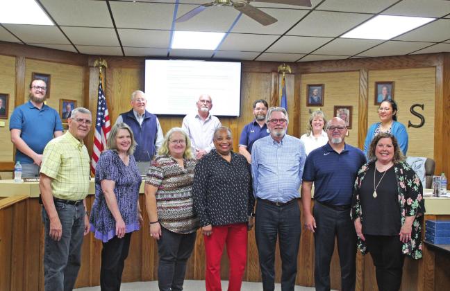 The Shawnee Board of Education honored those school employees who are retiring this year at their May 2 meeting. Shown, front row from left, are John Stell, Pam Hodges, Sharon Ferguson, Brenda Webb, Steve Maple, Todd Boyer and Kristi Heilaman. The board members in the back row are Turner Bass, Larry Walker, Keith Sandlin, Clif Harden, April Stobbe, and Kristen Wilson. Those retirees not pictured are Donna Hibler, Patricia Koehler, Pamela Sparks, Vera Elrod, Norma Neely, Beverly Permetter and Pam Woods.