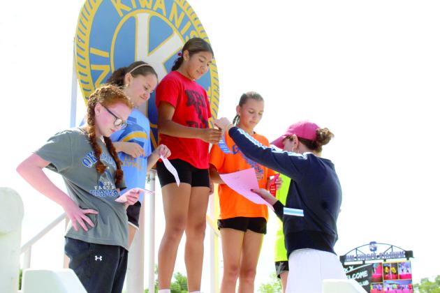 Fhionna Schaughnessy hands out ribbons for the 400 meter run.
