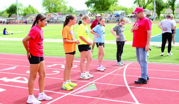 Kiwanis Club member Carl Packwood gives a group of girls last minute instructions for the 400 meter run.